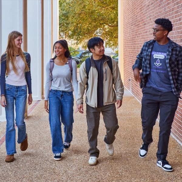 Four students walking on Cochran campus