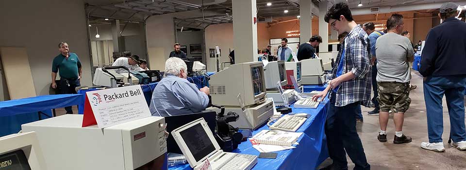 A student typing on one of the many old computer keyboards in the museum display