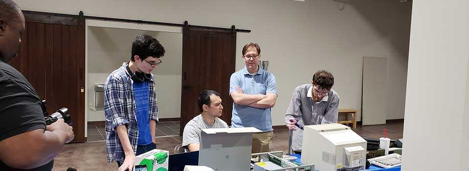 A group looking on the parts of old computers