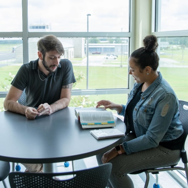 Two students seated at a round table at Aviation Hall