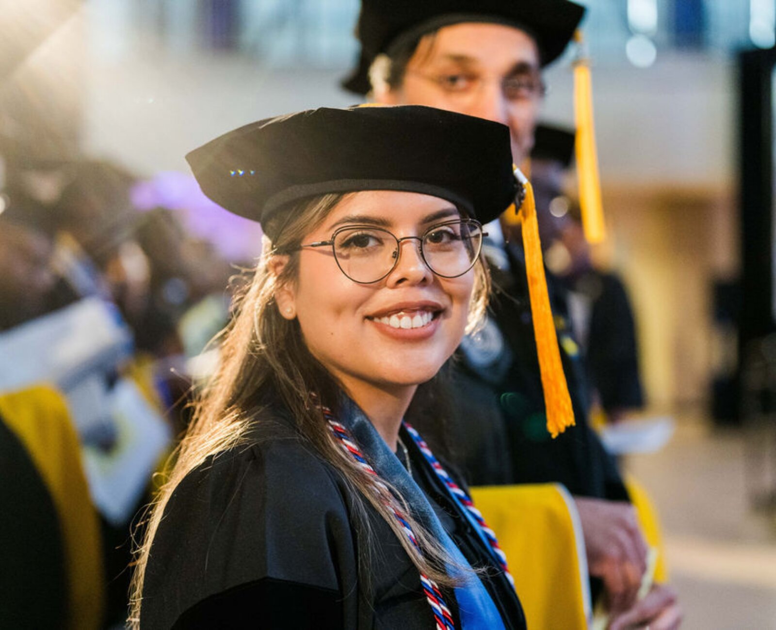 a graduate celebrating with her graduation regalia and master's cap