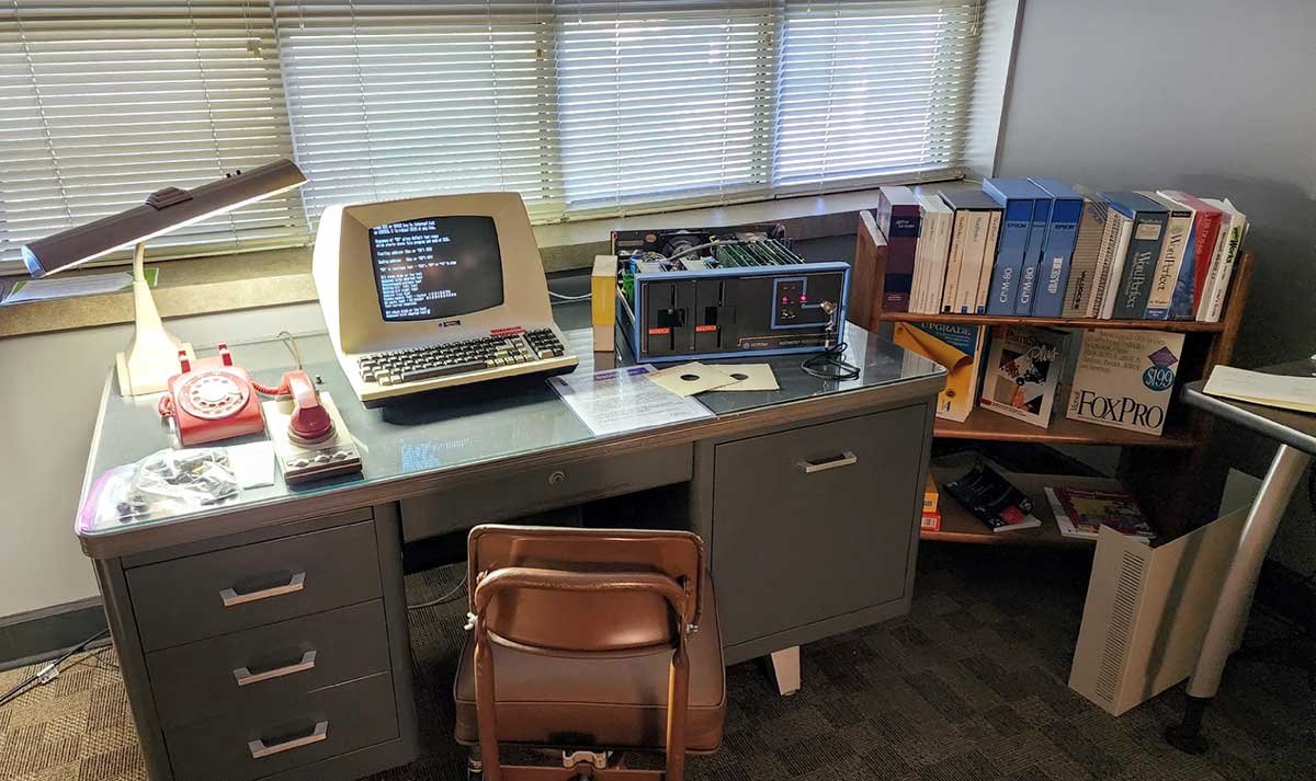 a desk with a vintage computer and electronics on it.