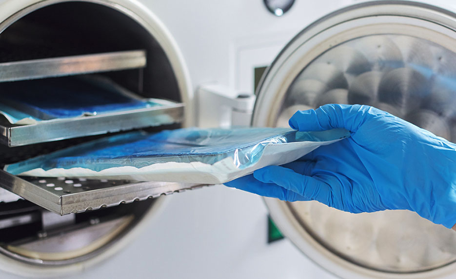 gloved hand handling sterilized medical equipment