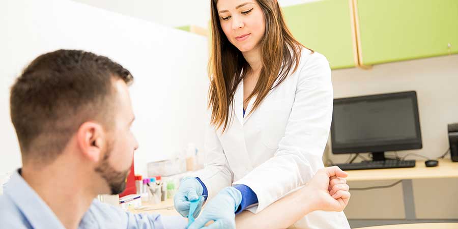 A phlebotomy tech getting ready to draw a patients blood.