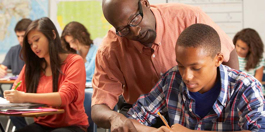 A teacher helping a student in a classroom.