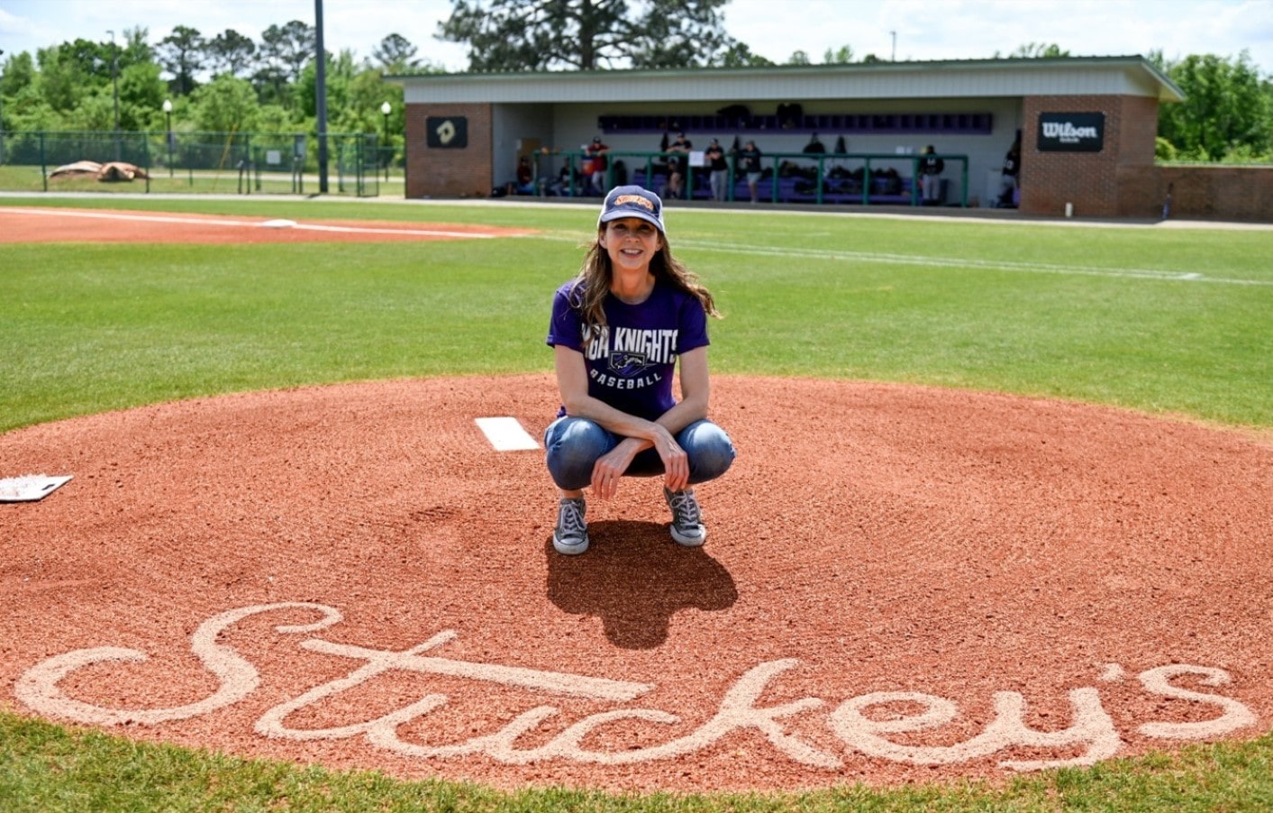 stephanie stuckey on the stuckey field pitching mound with the stuckey's logo drawn on the dirt