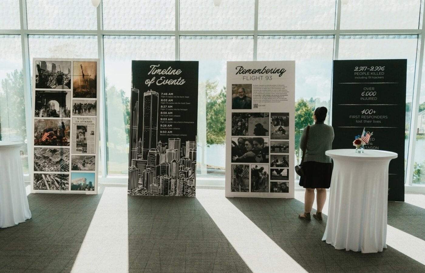 A lecture attendee reading the four floor banner information commemorating 25 years of 9.11