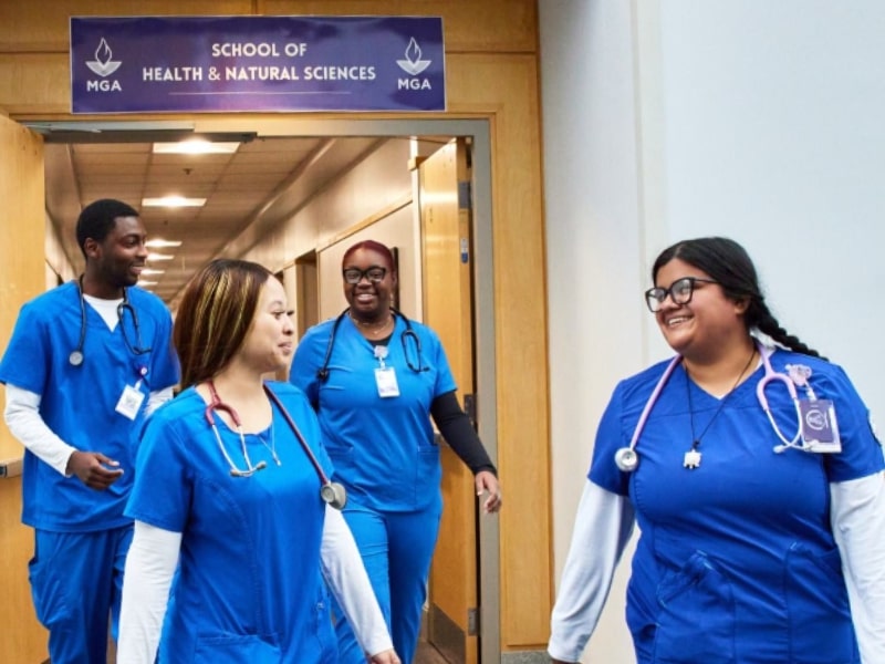 Four students in scrubs walking 