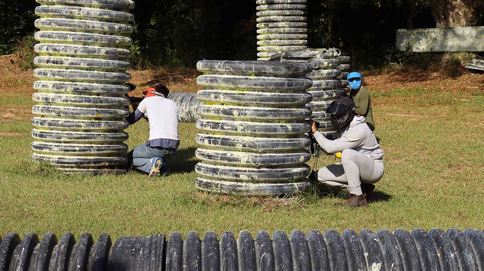 Students taking cover during a game of paintball