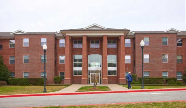 Knights hall, a brown brick residence hall with three tall glass entryways and white columns