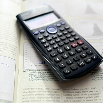 Photo of a scientific calculator sitting on top of a textbook