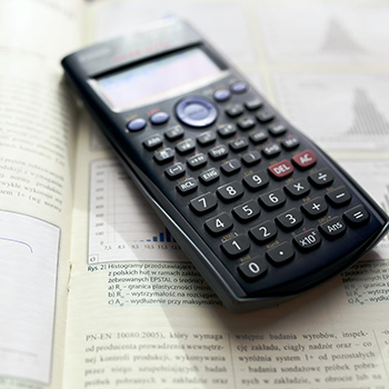 Photo of a scientific calculator sitting on top of a textbook