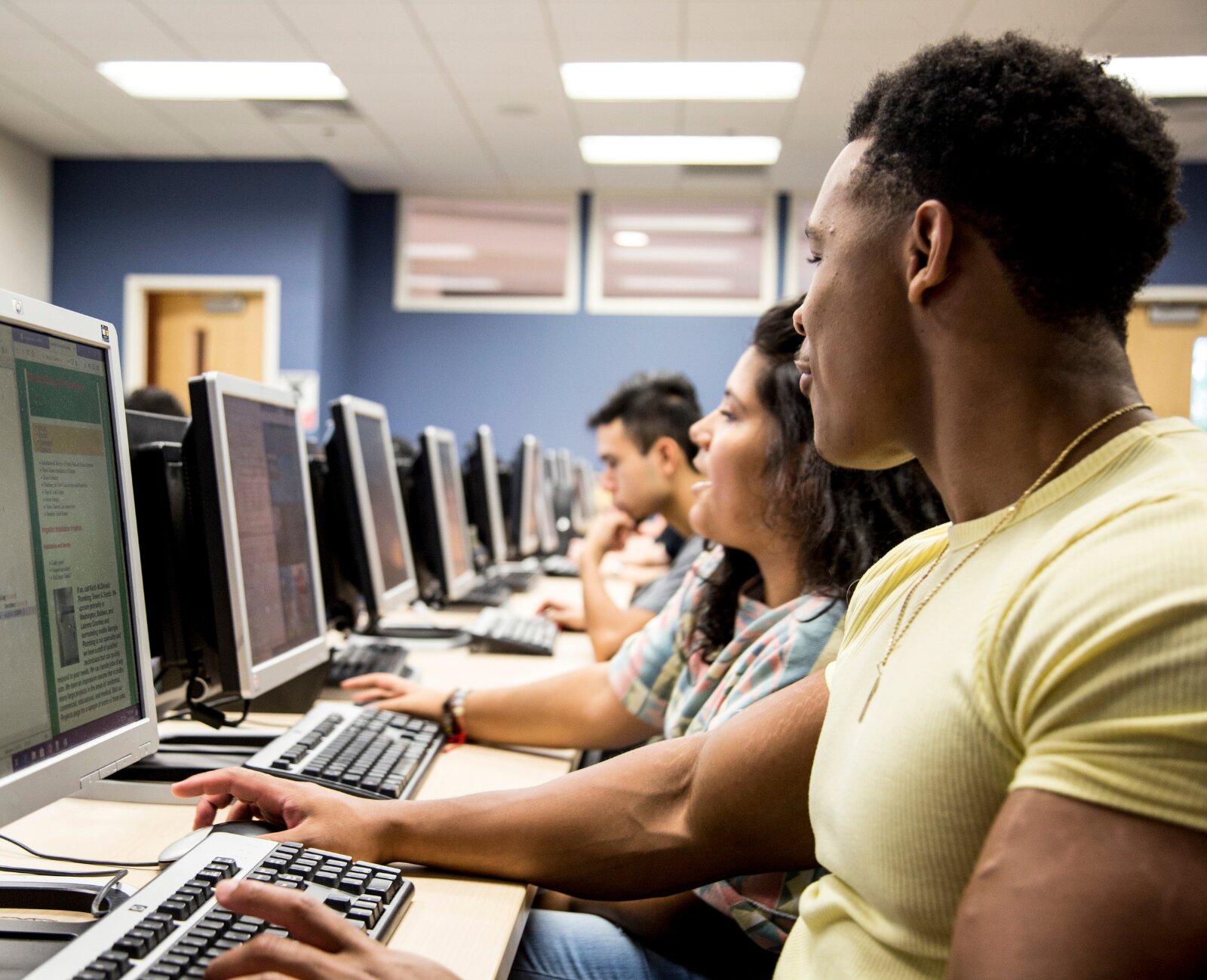 Two students discussing their code in a computer lab class